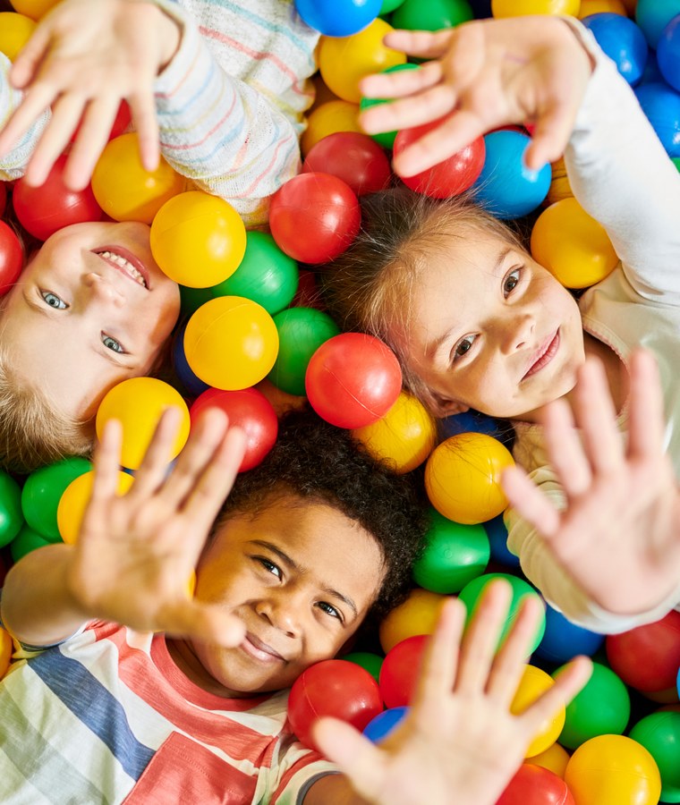 Children playing in a colourful ball pit