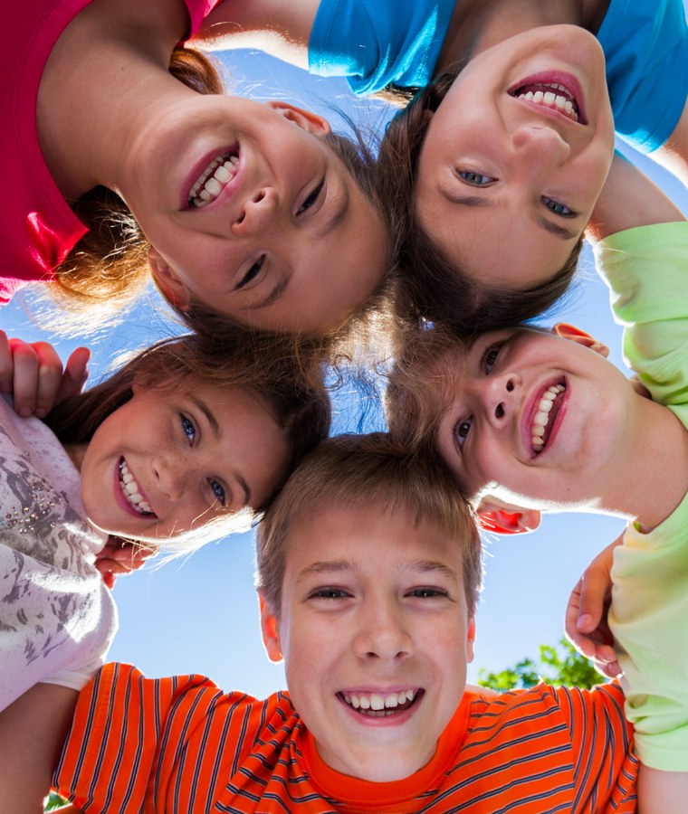 Children huddled together laughing outdoors