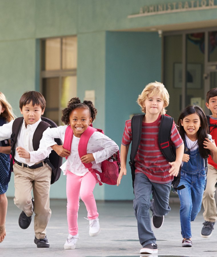 Children running with backpacks outside school